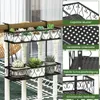 A black metal plant stand with multiple tiers, holding various potted succulents, is shown hanging on a railing outdoors. Produktbild-Vorschau
