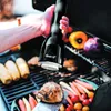 A person is using an electric grinder to season a piece of meat on a grill with various vegetables in the background. Náhled obrázku produktu