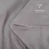 A close-up view of a soft, gray blanket, folded to show its texture and stitching. Text and icons indicating warmth are present. Anteprima dell’immagine prodotto
