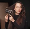 A woman is using a hairdryer to style her hair. Podgląd zdjęcia produktu