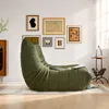 A green beanbag chair is placed in a living room setting with artwork on the wall and a side table. Produktbild-Vorschau