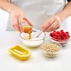A person is pouring honey into a bowl of yogurt, with raspberries and oats nearby, and a yellow popsicle mold in the foreground. Produktbild-Vorschau
