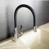 A modern kitchen faucet with a flexible black hose and a silver base, installed over a cream-colored sink. Náhľad obrázku produktu