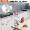 A manual meat grinder is shown on a kitchen counter, with raw meat in the hopper and ground meat on a plate. Text overlays describe its features and brand. Náhled obrázku produktu