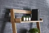 A wooden shelf unit with books and plants against a brick wall. Voir les images du produit