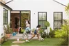 A family and their dog are playing in the backyard of a modern house. Voir les images du produit