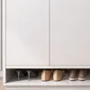 A close-up of a white shoe cabinet with several pairs of shoes stored underneath. Náhľad obrázku produktu
