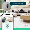 A young man is relaxing on a couch while a smart home camera monitors the room, with a phone displaying the camera feed. Produktbild-Vorschau