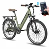 A green electric bicycle with a brown seat and handlebars, shown from a three-quarter front angle against a white background. A hand holding a smartphone displaying an app interface is superimposed on the upper right side of the image, with a wireless sign Produktbild-Vorschau