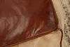 Close-up view of the corner of a pouf, showing the texture of the leather and fabric. Produktbild-Vorschau