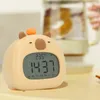 A cute capybara-shaped alarm clock is displayed on a table. Náhled obrázku produktu