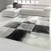 A modern living room with a white sectional sofa and a geometric rug. Produktbild-Vorschau