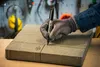 A gloved hand is marking a stone paver with a black marker. Anteprima dell’immagine prodotto