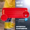 A child's yellow rain boots and a red swing seat are shown in a wet outdoor environment, with text highlighting product features. Produktbild-Vorschau