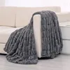 Graue strukturierte Kunstfell-Decke über der Armlehne eines hellbeigen Sofas im Wohnzimmer drapiert Náhľad obrázku produktu