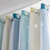 A close-up view of several colorful curtains hanging from a rod. Voir les images du produit