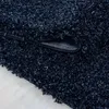 A close-up view of a dark navy blue shaggy rug, with a corner lifted to show the backing. Anteprima dell’immagine prodotto