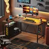 A gaming setup with an L-shaped desk, computer, monitor, keyboard, and accessories, in a room with gaming-themed decor. Anteprima dell’immagine prodotto