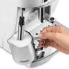 A hand is holding a milk frothing pitcher under the steam wand of a coffee machine. Produktbild-Vorschau
