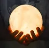 Hands holding a glowing moon-shaped humidifier emitting mist. Podgląd zdjęcia produktu
