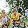 People enjoying a barbecue outdoors with corn and skewers. Produktbild-Vorschau