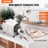 A stainless steel grain mill with a hopper is shown on a kitchen counter, with flour, eggs, and kitchen tools nearby. Produktbild-Vorschau