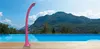 A pink outdoor shower stands beside an infinity pool with a mountainous landscape in the background. Produktbild-Vorschau