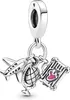 A silver charm with airplane, globe, and suitcase motifs. Podgląd zdjęcia produktu