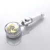 A shower head with a clear casing showing a golden propeller and a white handle, placed on a reflective surface. Produktbild-Vorschau