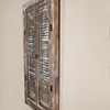 A wooden wall mirror with shutter-style doors, mounted on a plain wall. Anteprima dell’immagine prodotto