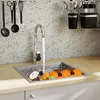A kitchen sink with a faucet running water into it, filled with various fruits. Produktbild-Vorschau