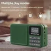 A green portable radio is shown on a wooden surface with a blurred background. Produktbild-Vorschau