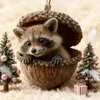 A cute raccoon peeking out of an acorn ornament, surrounded by miniature Christmas trees and a gift. Produktbild-Vorschau