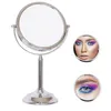 A silver makeup mirror with two inset circular images showing a woman's face and eye with colorful makeup. Produktbild-Vorschau