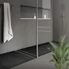 A modern bathroom with a shower drain and a towel hanging on a rack. Podgląd zdjęcia produktu