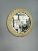 A round mirror with a gold ornate frame hangs on a light gray wall. The mirror reflects a shop interior. Náhľad obrázku produktu