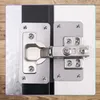 A close-up view of a metal hinge repair plate attached to two surfaces, likely a door and a frame, set against a wooden background. Náhľad obrázku produktu