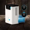 A white dehumidifier is shown on a wooden surface, with a glass container of water next to it. Icons indicating features are displayed. Produktbild-Vorschau