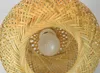 A close-up view of the top of a bamboo pendant light fixture with a light bulb inside. Produktbild-Vorschau