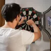 A man is playing darts in a room. Náhľad obrázku produktu