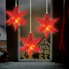Three red star-shaped LED lights hang in a window at night, with a snowy scene and a gingerbread house visible outside. Anteprima dell’immagine prodotto