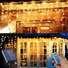 A collage of two images showing outdoor decorative lights. The top image shows icicle lights hanging from a building's eaves. The bottom image shows the same lights draped over a structure with a solar panel and remote control visible. Produktbild-Vorschau