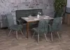 A dining set with a bench and chairs around a table, set against a stone wall. Produktbild-Vorschau