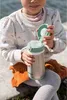 A child is holding a stainless steel straw cup outdoors. Podgląd zdjęcia produktu