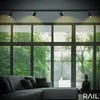 A modern living room with a large window overlooking a lush forest. A comfortable sectional sofa with accent pillows is placed in front of the window. A Buddha statue sits in the corner. Anteprima dell’immagine prodotto