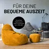 Two corduroy beanbag chairs and a pouf are arranged in a living room setting with a small side table and a lamp in the background. Náhled obrázku produktu