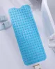 A blue anti-slip bath mat is laid out on a white surface, with a bathtub and light blue slippers visible in the background. Anteprima dell’immagine prodotto