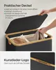 A person is opening the lid of a black laundry basket with a bamboo rim. The basket contains laundry. Produktbild-Vorschau