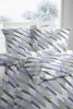 A bed with bedding in a room with a window showing a winter scene. Produktbild-Vorschau