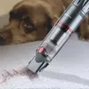 A close-up of a handheld vacuum cleaner cleaning pet hair from a carpet, with a dog lying in the background. Produktbild-Vorschau